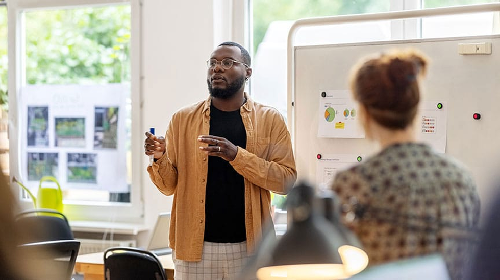 A business leader discussing problems at a whiteboard.